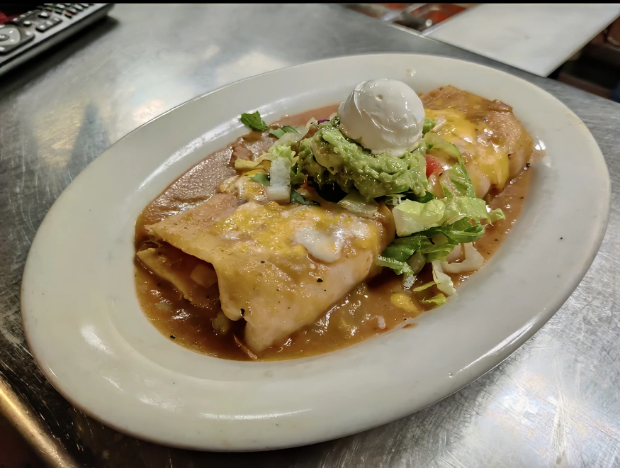 Ala Carte Burrito Smothered in chile verde or enchilada sauce and topped with cheddar and Monterey Jack cheese, lettuce, tomato, sour cream, and guacamole.