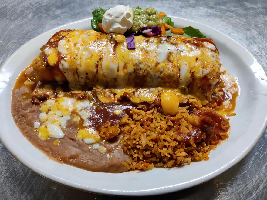 Burrito Platter Smothered in chile verde or enchilada sauce, topped with cheddar and Monterey jack cheese, lettuce, tomato, sour cream, and guacamole. Served with spanish rice or fideo and refried beans.
