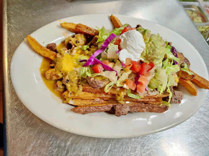 Chili Fries Fresh cut fries, fried to crispy perfection. Topped with a delicious blend of cheddar and Monterey jack cheese and smothered in chile verde or enchilada sauce. Garnished with lettuce, tomato. sour cream, and guacamole.