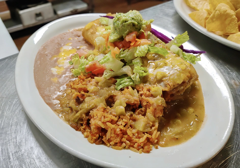 Ala Carte Chimichanga Smothered in chile verde or enchilada sauce and topped with cheddar and Monterey Jack cheese, lettuce, tomato, sour cream, and guacamole.